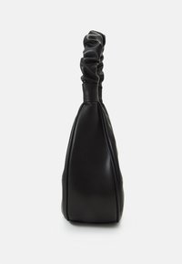 Sac à main en cuir noir avec une anse froncée, posé debout sur un fond blanc uni.