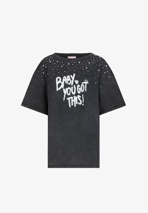 T-shirt nera oversize con borchie argentate sulle spalle e testo bianco "BABY YOU GOT THIS!" stampato sul davanti.