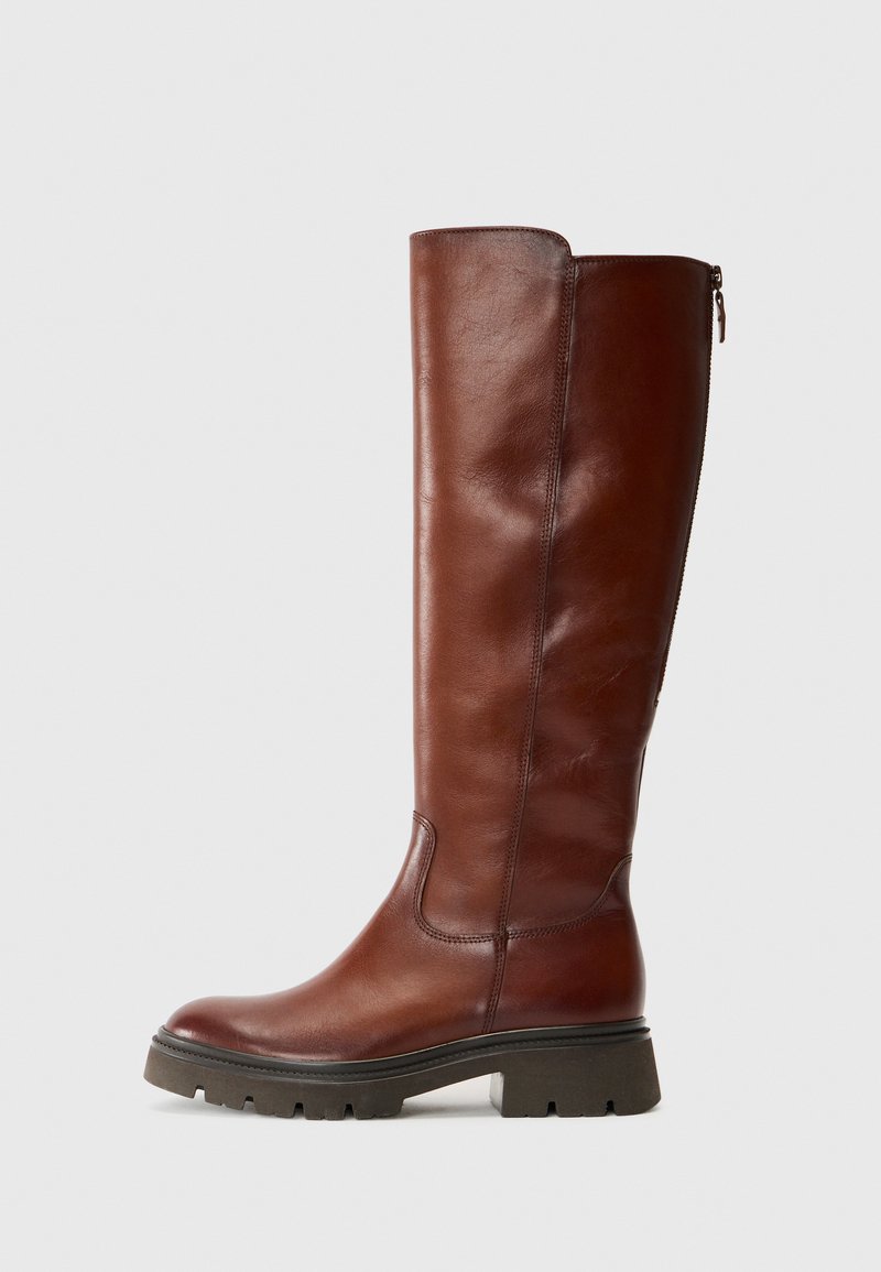Braune Lederstiefel bis zum Knie mit glatter Oberfläche, runder Spitze und klobigem schwarzen Gummisohle. Verfügt über einen seitlichen Reißverschluss und ein elastisches Paneel.