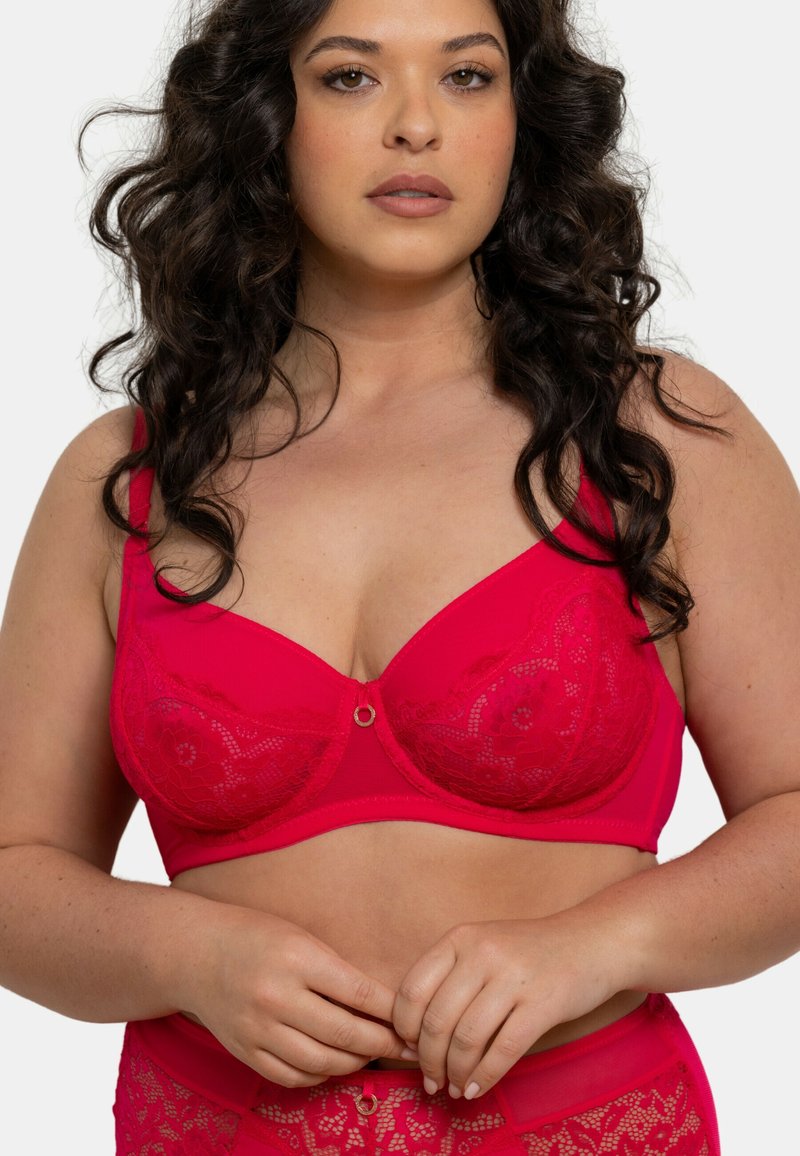 Soutien-gorge en dentelle fuchsia avec des bonnets à armatures, un superposé de dentelle décorative et un accent en anneau central. Conçu avec des bretelles réglables et une bande lisse.