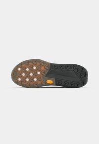 Czarna i brązowa gumowa podeszwa buta z teksturowanym wzorem, z sercowymi wypustkami i żółtym logo Vibram.