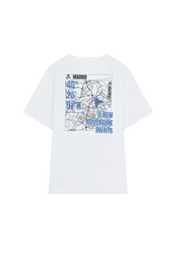 Witte T-shirt met een grafische print van een kaart met coördinaten en de tekst "MADRID" en "EEN NIEUWE AVONTUUR WACHT" in het blauw. Korte mouwen.