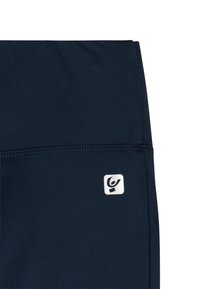 Pantalones cortos deportivos azul marino hechos de tela elástica con una textura suave. Presentan un parche de logo blanco y costuras planas para mayor comodidad.