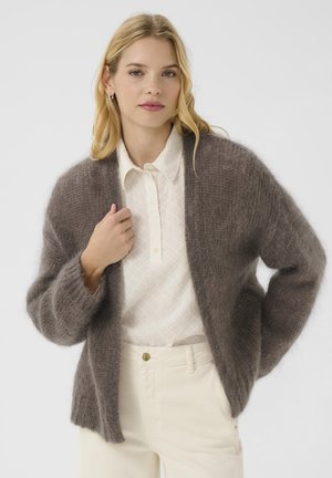 Brown mohair cardigan with a relaxed fit and wide sleeves, worn over a white textured blouse. Features open front and ribbed cuffs.