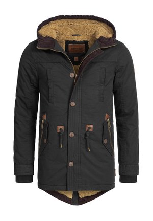 Veste à capuche noire avec une doublure en fausse fourrure beige, présentant un zip sur le devant, deux poches latérales avec des accents en cuir et des détails en bouton marron.