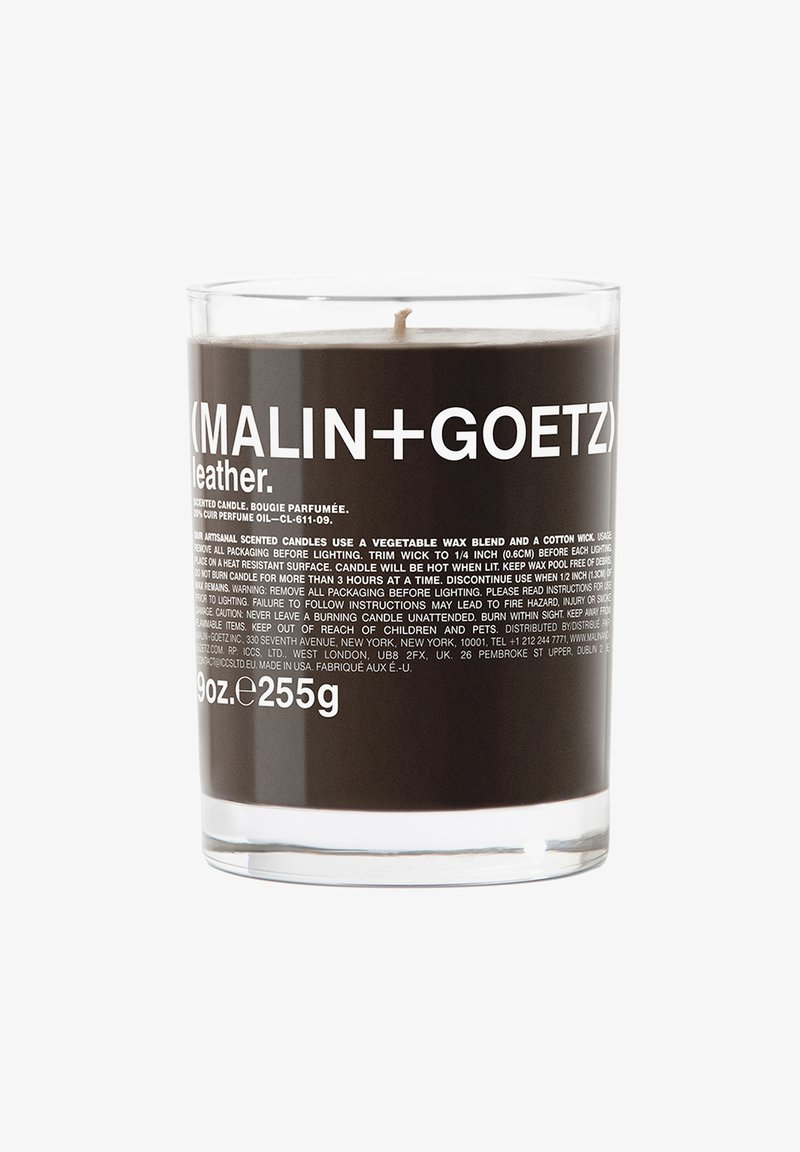 Duftkerze in einem klaren Glasgefäß, mit einer dunklen Wachsblende und fettem Schwarz-Weiß-Labeltext, der Produktdetails und Warnhinweise enthält.