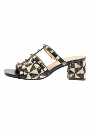 Black and beige woven mule sandal with block heel, studded black leather straps, and open toe.