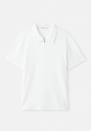 Camisa polo blanca de manga corta con tejido texturizado, un cuello y una cremallera en la parte delantera, etiquetada como Tiger of Sweden.