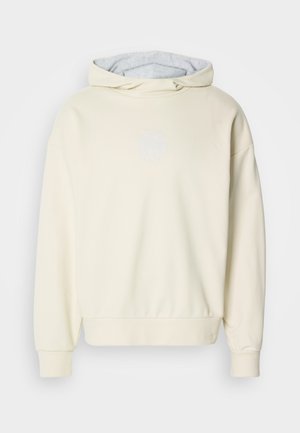 Crème-kleurige hoodie met een zachte textuur, voorzien van een grijze binnenvoering, verlaagde schouders en een subtiele logo op de borst.