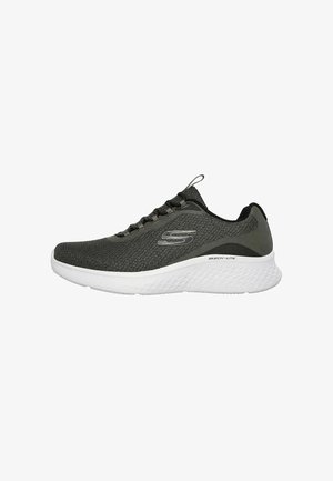 Zapatilla deportiva Skechers de color gris oscuro con suela blanca texturizada y cierre de cordones, vista de lado sobre un fondo blanco.