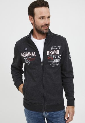 Sivi zip-up dukserica napravljena od mješavine pamuka, sa štampanim tekstom i grafikom s prednje strane, bočnim džepovima i rebrastim manžetama.