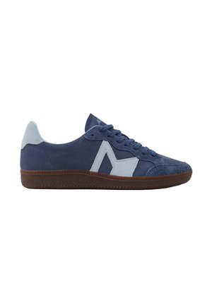 Baskets basses en daim bleu marine avec des détails bleu clair et une semelle marron texturée, vues de côté sur fond blanc.