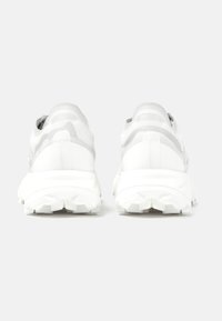 Bílé sportovní boty s mesh svrškem se šedými akcenty, strukturovanou podrážkou s hlubokými výstupky pro lepší trakci a polstrovanou patou.