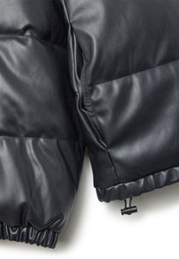 Chaqueta acolchada negra que combina cuero y tejido, con puños elásticos y un dobladillo con cordón para un ajuste ajustable.