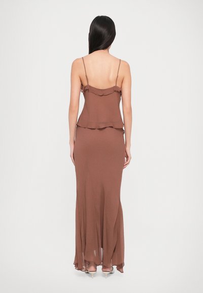 Brown, sleeveless maxi dress with shoulder straps; ruffled details at the neckline and hem, made of lightweight fabric.