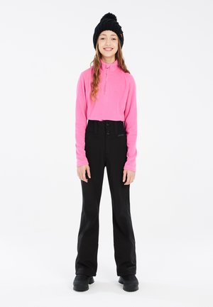 Pulóver de forro polar rosa con media cremallera, combinado con pantalones negros de cintura alta que cuentan con dos botones. Un gorro de punto negro y calzado negro resistente complementan el conjunto.