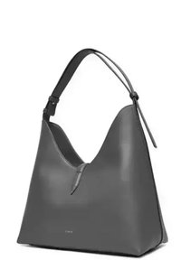 Borsa a spalla in pelle grigia con silhouette a V, texture liscia, tracolla regolabile e branding discreto nella parte inferiore.