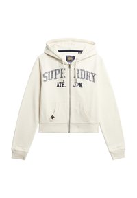 Sudadera corta color crema con cremallera frontal, que presenta bordado en texto "SUPERDRY ATH. JPN" en azul marino, dos bolsillos frontales y puños acanalados.