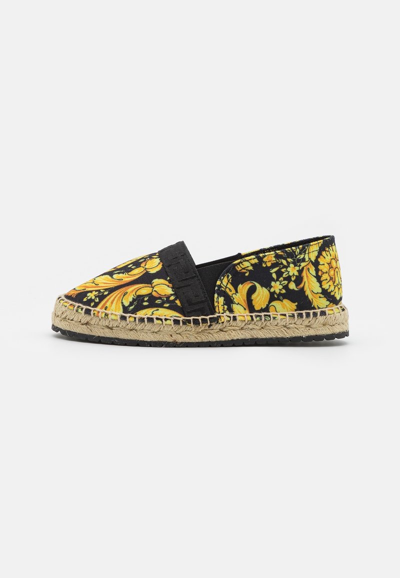 Espadrille noire à enfiler avec motif baroque floral jaune et semelle en jute tressée avec semelle en caoutchouc noir, vue de côté.