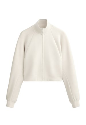 Cropped white zip-up jacket made from ribbed fabric, with a high collar and raglan sleeves, featuring a flat texture and side pockets.