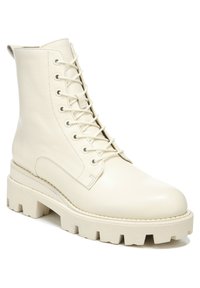 Bottines en cuir blanc avec une plateforme légèrement surélevée et une semelle robuste, arborant un design classique à lacets et un bout arrondi.
