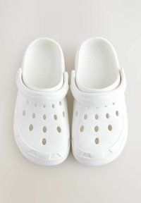 Weisse Clogs aus strukturiertem Kunststoff, mit Belüftungslöchern, einem erhöhten Fersenriemen und einem abgerundeten Zehendesign. Glatte Oberflächenbeschaffenheit.