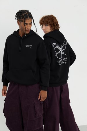 Black hoodies feature a front pocket and drawstring hood. The back displays a white butterfly graphic and “NEVER FINISH ANYTHNG” text.