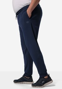 Marineblaue Jogginghose mit elastischem Taillenbund und verstellbarem Kordelzug. Seitentaschen, taillierter Schnitt und Logodetail am Bein.