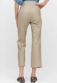 Beige neplederen cropped broek met hoge taille, gekenmerkt door een soepele textuur en verticale naden, gecombineerd met flats in luipaardprint.