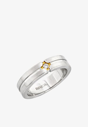 Silberner Breil-Ring mit einem einzelnen runden Diamanten, gefasst in eine goldene sternförmige Krappenfassung, mit einem glatten, gerillten Banddesign.