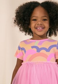 Klänning med en ribbad, multifärgad överdel med vågmönster i rosa, lila och grönt, samt en lager-på-lager rosa tyllkjol.