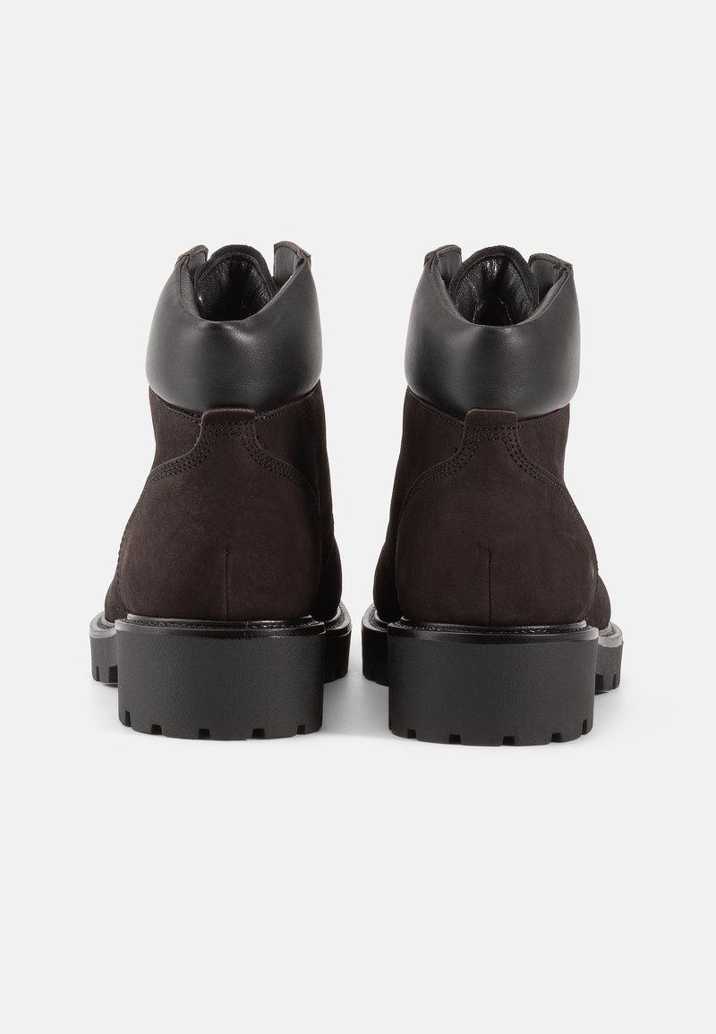 Zwarte suède enkellaarsjes met een gladde zwarte leren kraag, robuuste zwarte rubberen zool en stikdetails langs de naden.