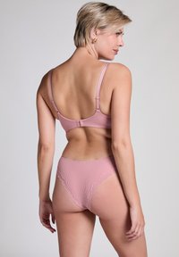 Rosa gerippter BH und passendes Höschen-Set mit Spitzenakzenten, verstellbaren Trägern und einem Hakenverschluss hinten. Glatte Textur.