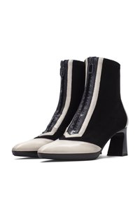 Svarta mocka ankelstövlar med en beige lackläder tåhätta, med en främre dragkedja, en texturerad panel och en fyrkantig klack.