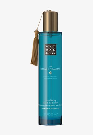 Bouteille cylindrique bleue du Ritual of Hammam brume revitalisante pour cheveux et corps avec bouchon doré et pompon, étiquetée eucalyptus et huile d’argan.