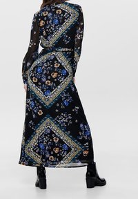 Robe maxi noire avec imprimés floraux bleus et oranges. Comprend un tissu transparent, des manches longues et une bordure à motif avec des accents dorés.