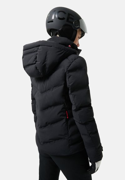 Schwarze Pufferjacke mit Kapuze, mit einem gesteppte Design, roten Akzenten und einer schlanken Form. Getragen mit einem schwarzen Helm.