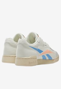 Sneakers bianchi in pelle con accenti azzurri chiari e pesca, colletto imbottito e suole in gomma testurizzata. Logo Reebok visibile sul tallone.