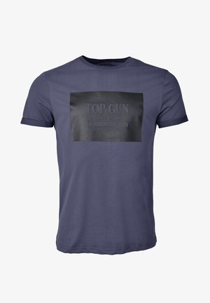 Granatowa bawełniana koszulka z krótkim rękawem z czarną prostokątną naszywką z napisem "TOP GUN 69TH DIVISION AN AMERICAN ICON" w wytłoczonym druku.