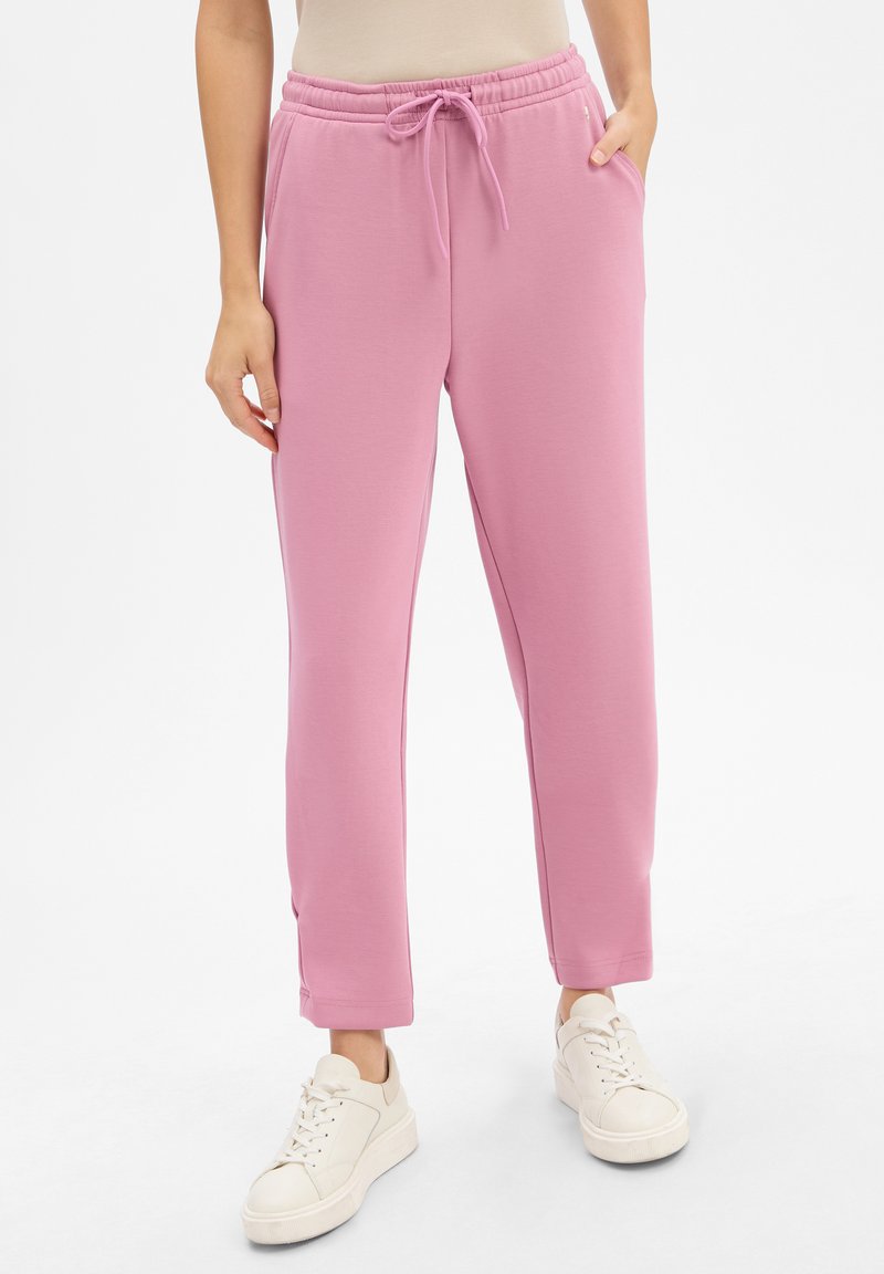 Hellrosa Jogginghosen aus weichem Stoff, mit einem elastischen Bund und Kordelzug, Seitentaschen und schmal zulaufenden Beinen.