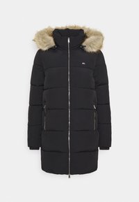 Černý dlouhý péřový kabát s kapucí s kožešinovým lemem, předním zipem, dvěma zipovými kapsami a malým logem na hrudi na bílém pozadí.