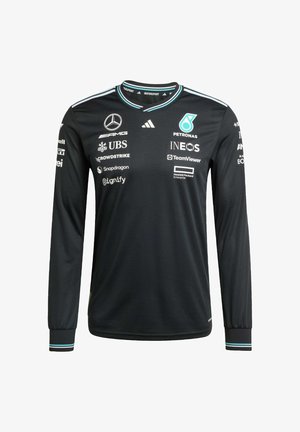 Jersey a maniche lunghe nera realizzato in tessuto traspirante. Presenta dettagli bianchi e teal, collo rotondo e vari loghi degli sponsor sul davanti.