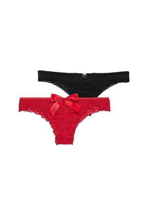 Due mutandine bikini da donna in pizzo, una nera con piccola decorazione, una rossa con grande fiocco in raso, su sfondo bianco.