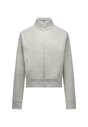 Lichtgrijze jas met ritssluiting, hoge kraag, lange mouwen, subtiele naaddetails en kleine "Marseille" tekst op de linkerborst.