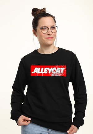 Zwarte sweatshirt met een gedurfde rode en witte grafische print met de tekst "ALLEYCAT", spetters en geribbelde boorden en zoom.