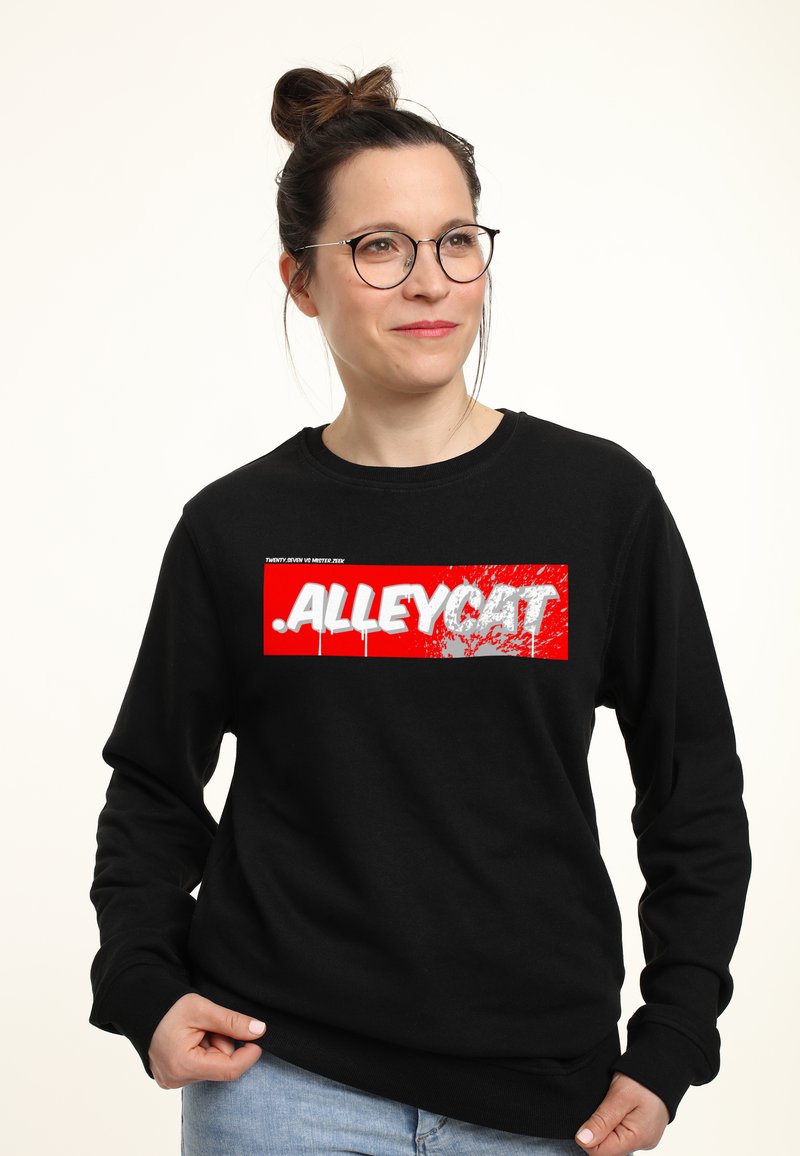 Černá mikina s výraznou červenou a bílou grafikou s nápisem "ALLEYCAT", akcenty postříkání a žebrovanými manžetami a lemem.