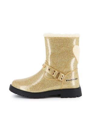 Botte mi-mollet pailletée dorée avec semelle noire, bride décorative avec clous, doublure en polaire crème et texte "BILLIEBLUSH" sur le talon.