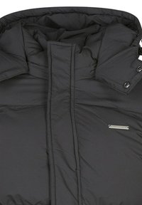 Veste matelassée noire avec col montant, coutures horizontales et badge logo métallique. Comprend des boutons-pression et un tissu lisse et texturé.