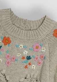Beige gebreide trui met bloemenborduurwerk in roze, oranje en blauw. Geribbelde halslijn en decoratieve accenten aan de zoom.