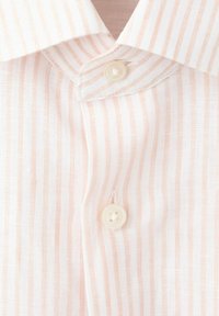 Vaaleanpunainen ja valkoinen pystysuuntainen raidallinen paita, jossa valkoiset napit ja terävä kaulus, kangasrakenteen yksityiskohdat näkyvissä.
